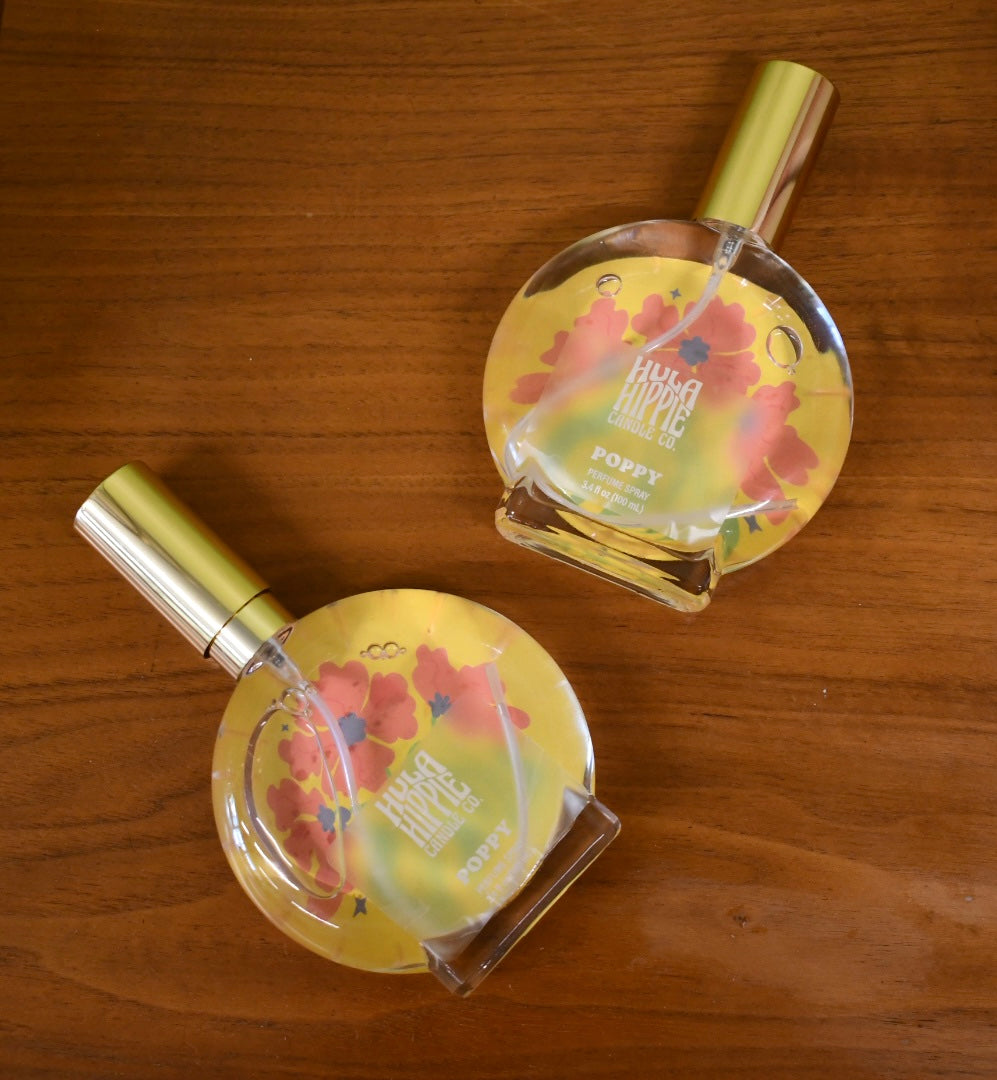 Two floral perfume bottles on a wooden surface