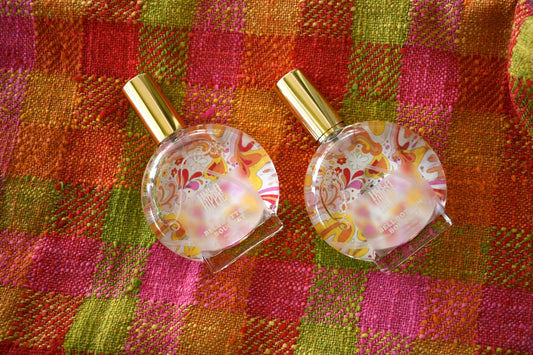 Round 100 ml Perfume glass bottle with image reversed and seen through bottle. Hula Hippie's Bell bottom bouquet scent. Plaid fabric background