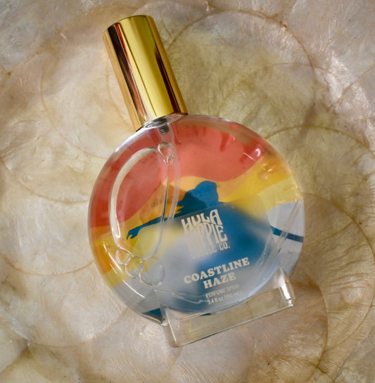 Perfume bottle labeled 'Coastline Haze' by Hula Magic on a textured surface