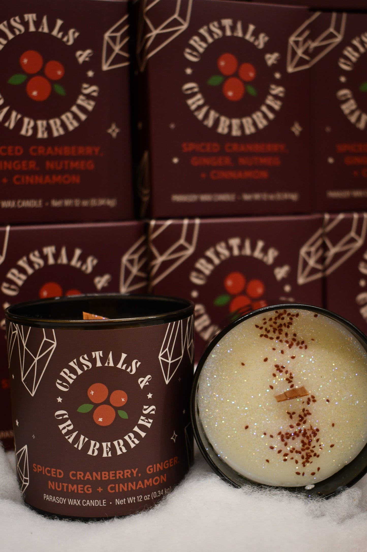 Christmas Hula Hippie Wood wick candle with a trail of cranberry seeds and sparkling glitter in a dark jar with a deep red label with cranberries