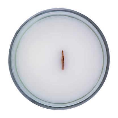Top view of a scented candle in an iridescent jar with a wooden wick labeled "North Shore" with notes of teakwood and jasmine.