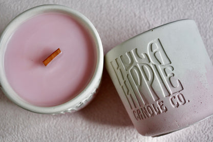 Pink candle in a white container with 'Hula Hippie Candle Co.' branding on a light background